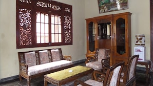 A traditional room with a sofa set, a wooden cabinet, and a dining table. - Villa Adas (Ngadisari)