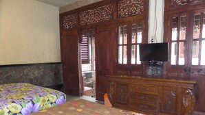 A room with two beds, a wooden dresser, and a television. - Villa Adas (Ngadisari)