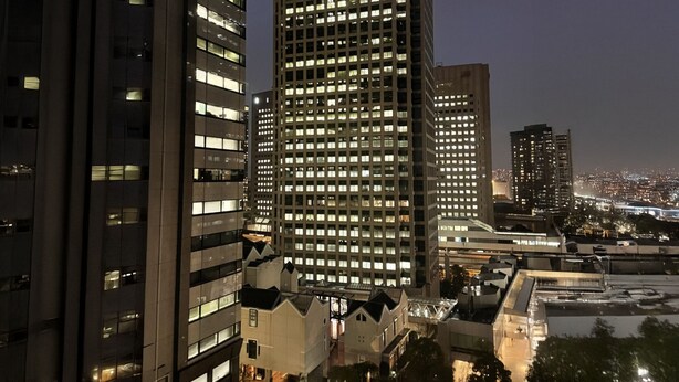 Een hoog gebouw met meerdere verdiepingen, grote ramen en een opvallende ingang bovenaan.