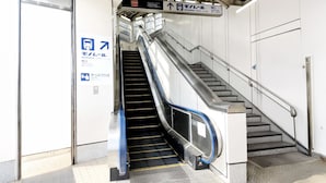An empty escalator leading to a staircase with a sign indicating the direction to the South Gate. - Toyoko Inn Shinagawa Konan Tennozu Isle (Tokyo)