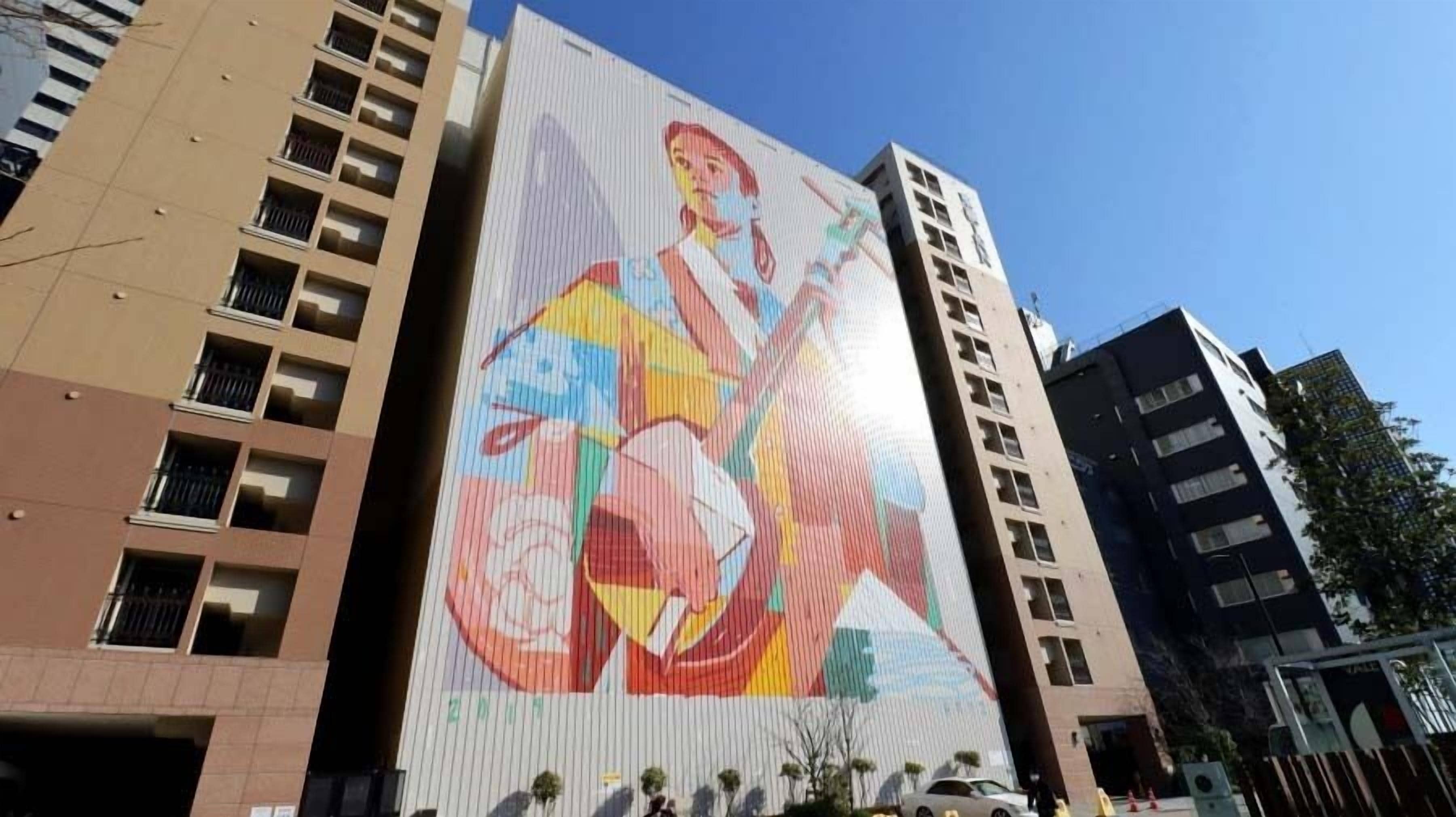A tall building with a large mural on its side.