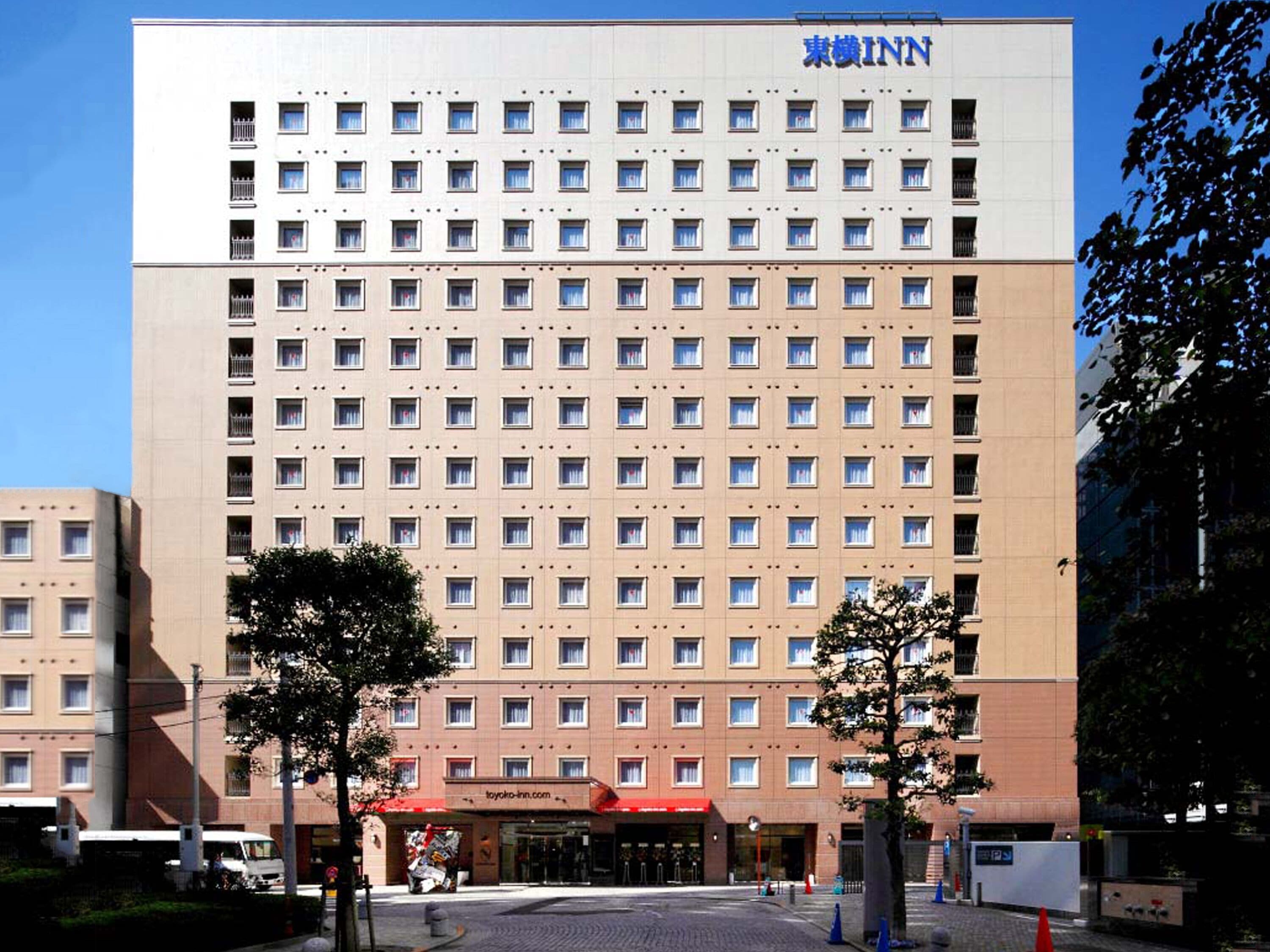 A multi-story hotel with a uniform facade, numerous windows, and a prominent signage for Toyako-inn.com.