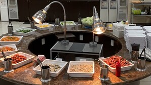 Een buffetopstelling met diverse gerechten en een koffiecorner.