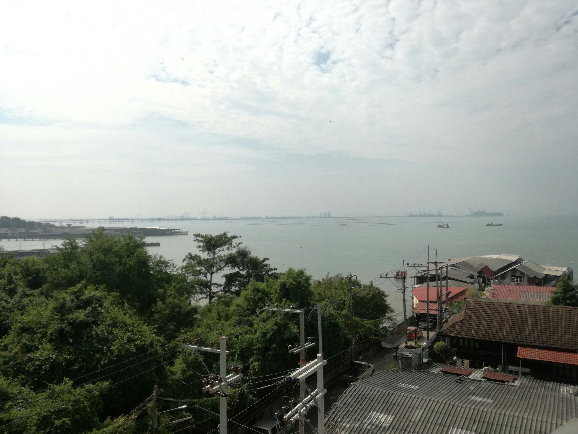 A coastal view with a bridge, boats, and buildings.