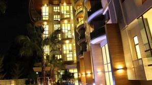 A multi-story hotel with balconies and a swimming pool. - Sonrisa Sriracha (Si Racha)
