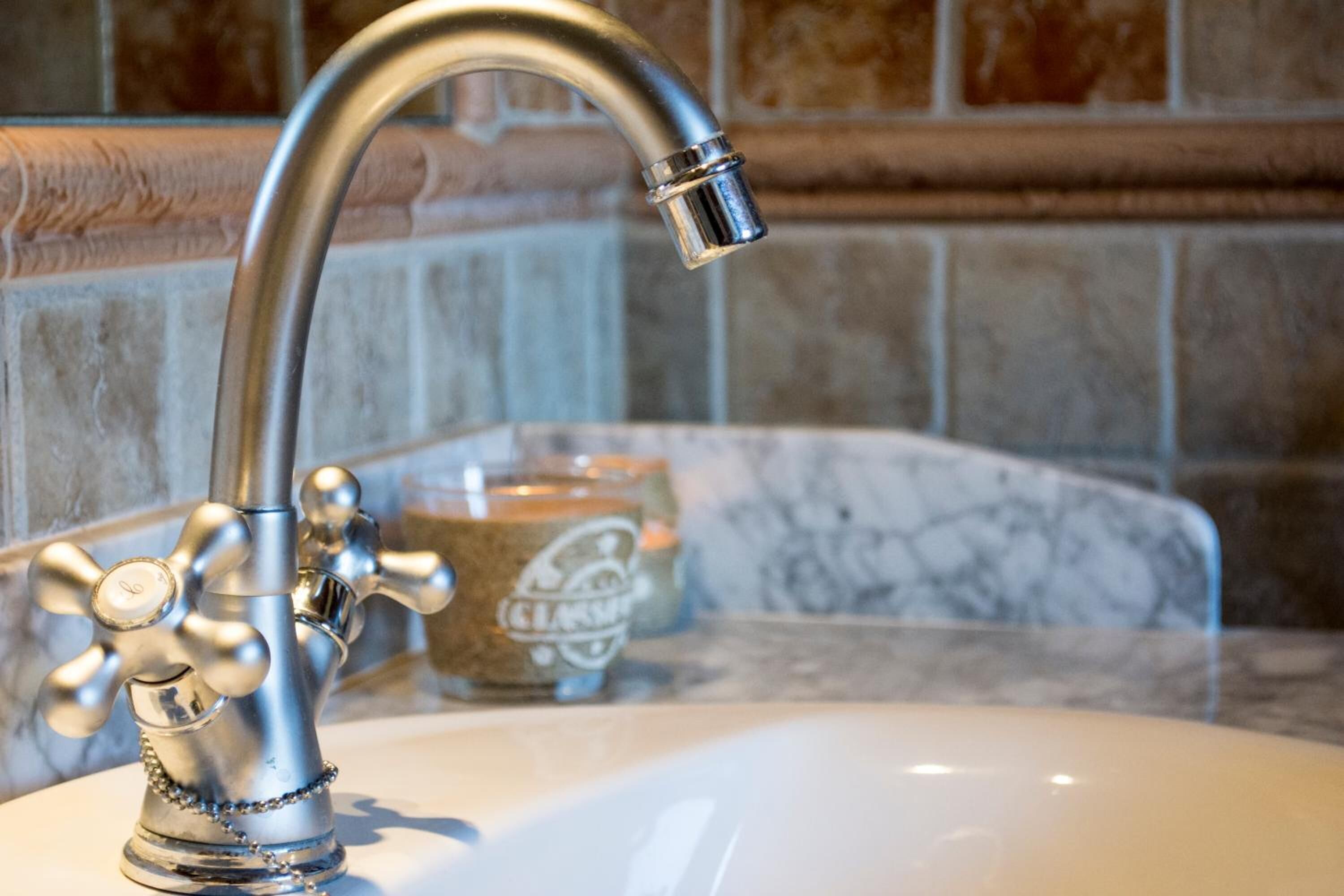 A bathroom sink with a chrome faucet and a soap dispenser.