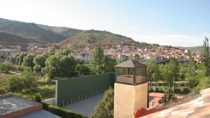 A view of a town with buildings and greenery, a watchtower, and a clear sky. - Casa Rural Los Garridos (Casas Bajas)