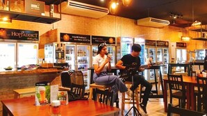 L’intérieur d’un restaurant avec des murs en briques, des tables en bois et un coin bar.