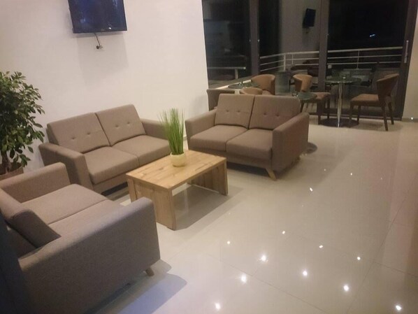 A modern living room with two sofas, a coffee table, and a potted plant.