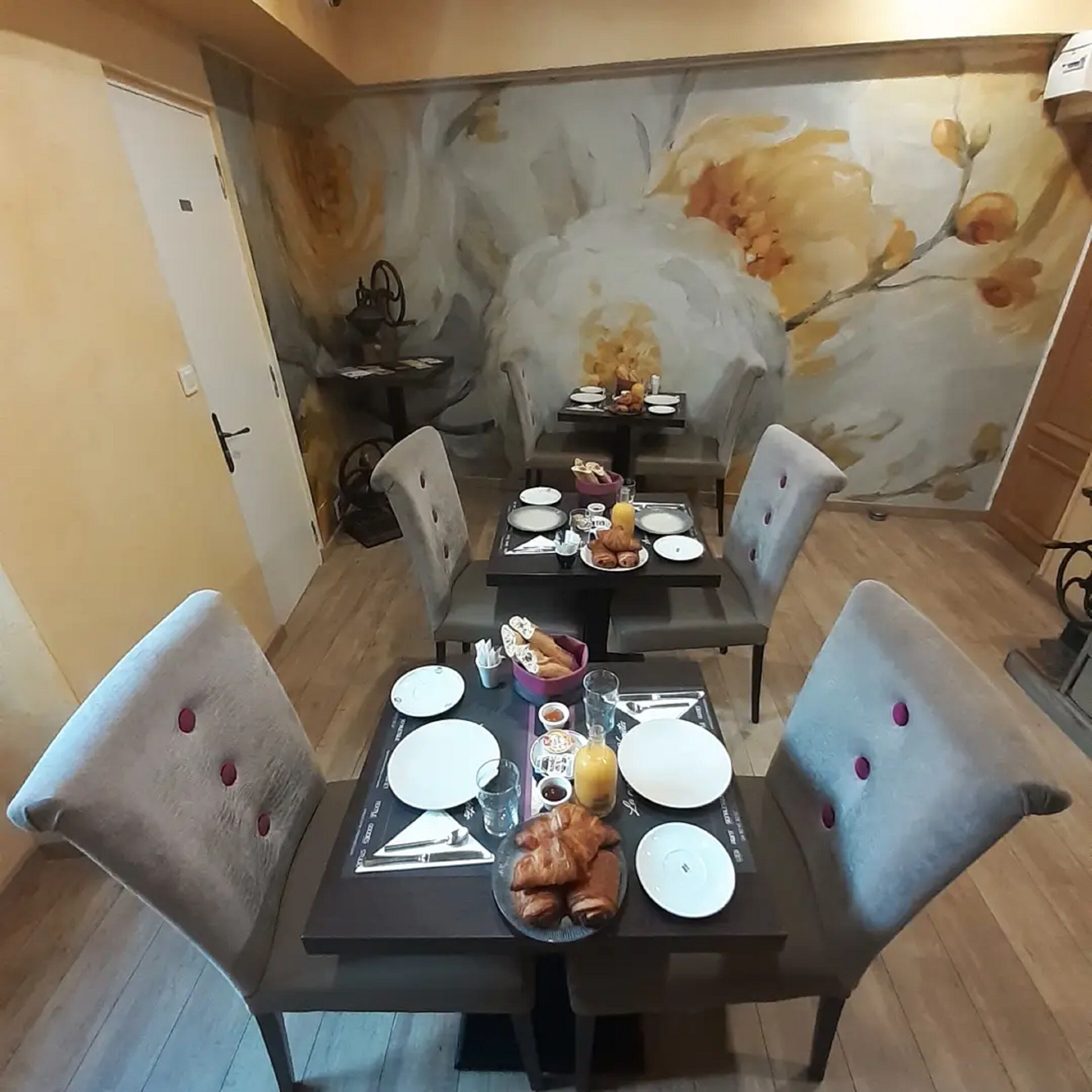 A dining area with a table set for four, including plates, cutlery, and a bread basket.