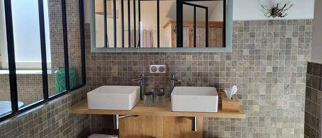 Une salle de bain avec deux lavabos, un miroir et un porte-serviettes.