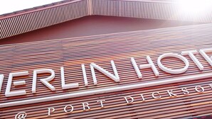 A wooden slatted floor with the text "MERLIN HOTEL" and "PORT DICKSON" indicating the hotel's name and location. - Merlin Hotel (Port Dickson)