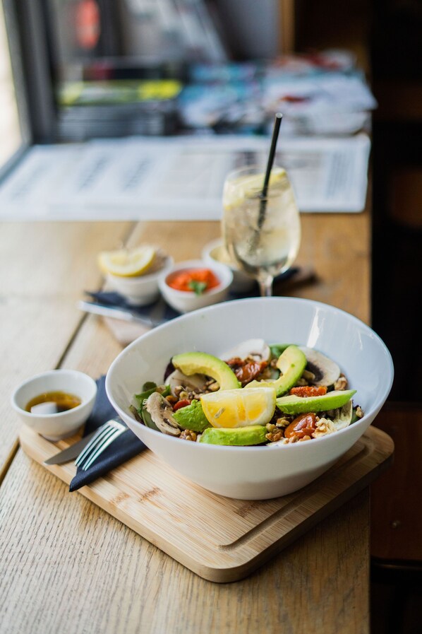 Ensalada con aguacate, limón y nueces sobre una tabla de madera.