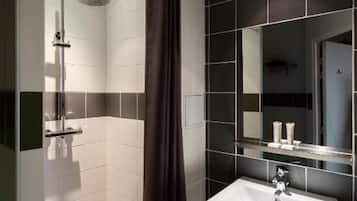 Een moderne badkamer met een douche, wastafel en spiegel.