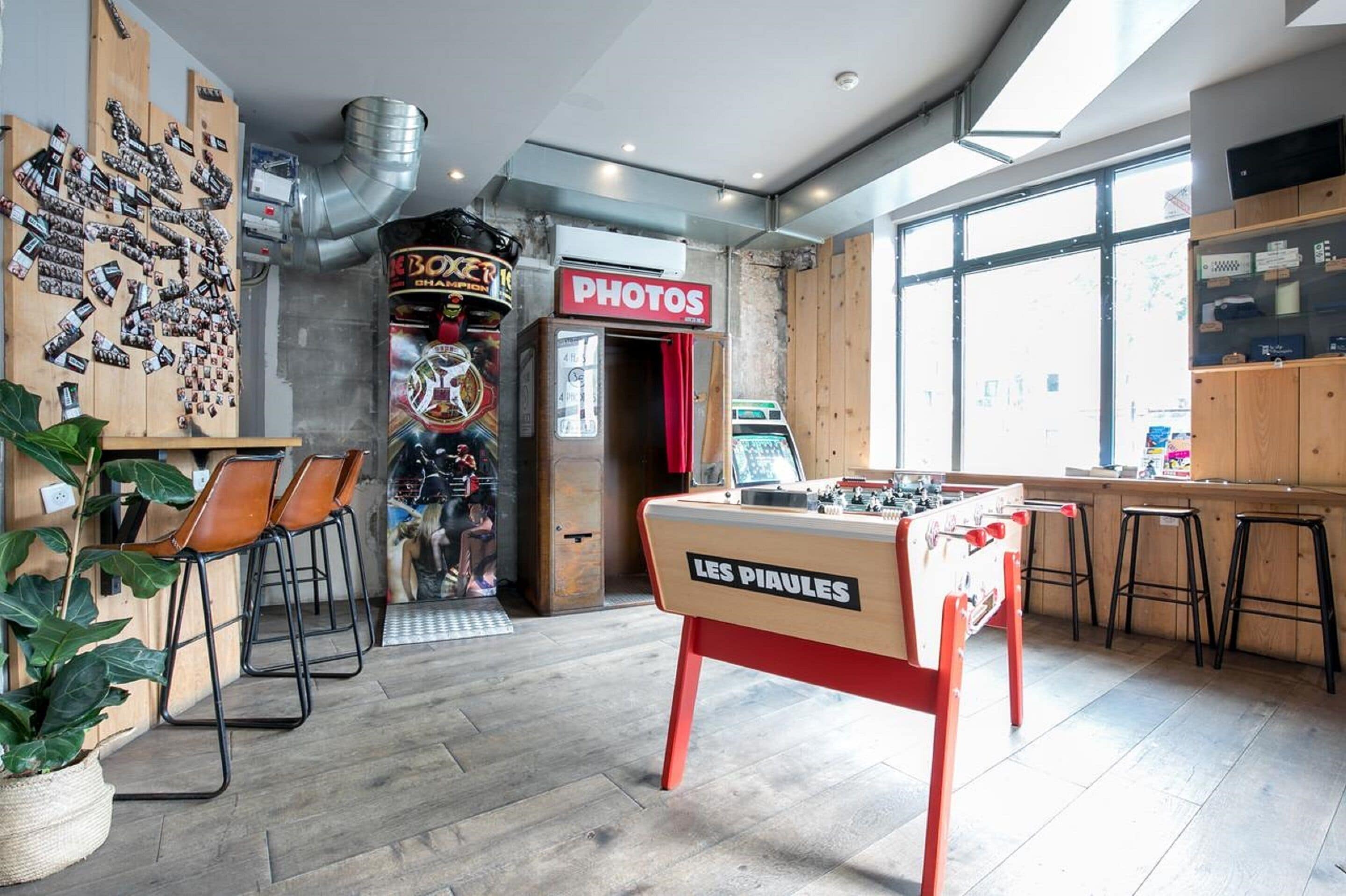 A cozy bar area with a foosball table, a photo booth, and a vintage arcade machine.