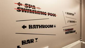 Una pared con indicaciones hacia el spa, la piscina, el baño y el bar.