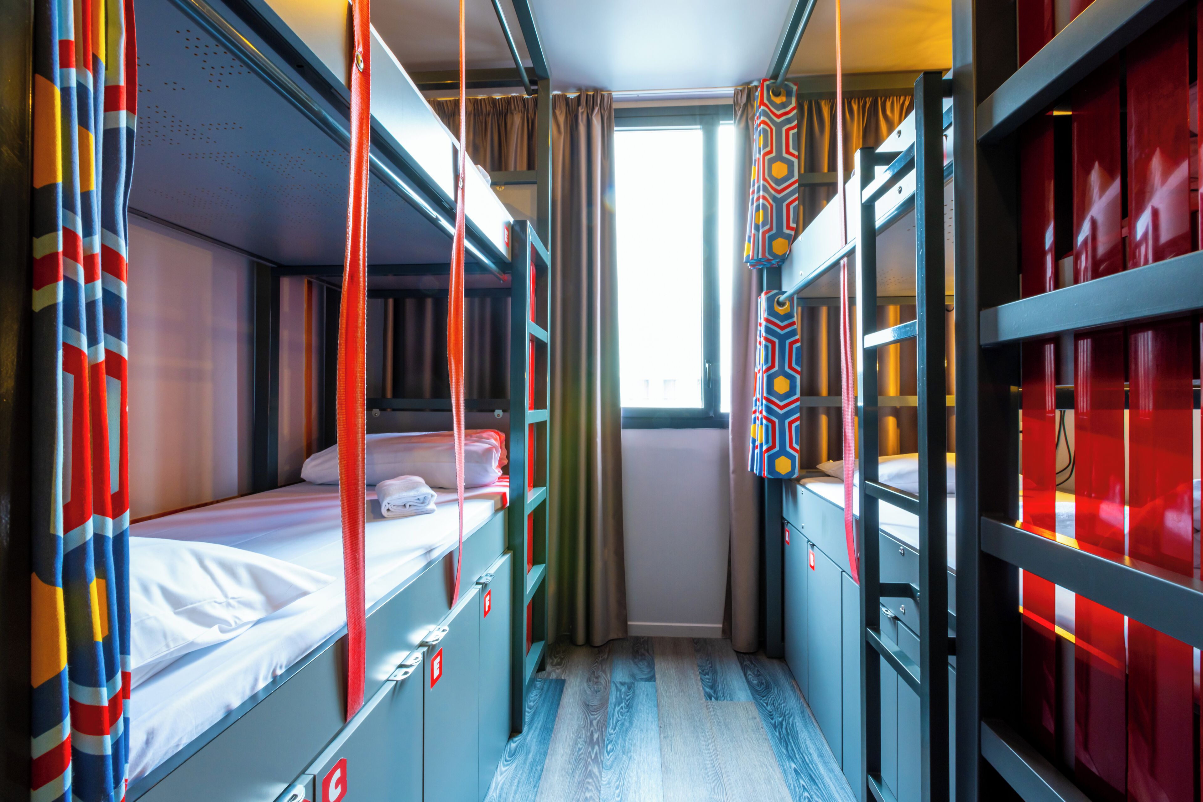 Un compartimento de tren con literas, cortinas y una ventana.