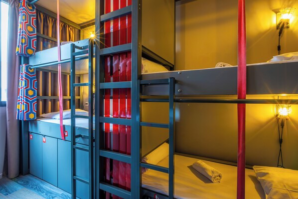 A bunk bed room with a ladder, a wardrobe, and a wall-mounted light fixture.