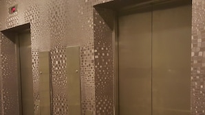 An elevator with a mosaic tile design on the walls and a metallic finish. - 9 Square Hotel - Kota Damansara (Petaling Jaya)