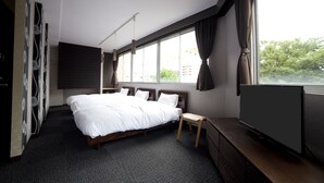 A modern hotel room with a large bed, a small seating area, and a TV on a stand. - Fukuwauchi (Tokyo)