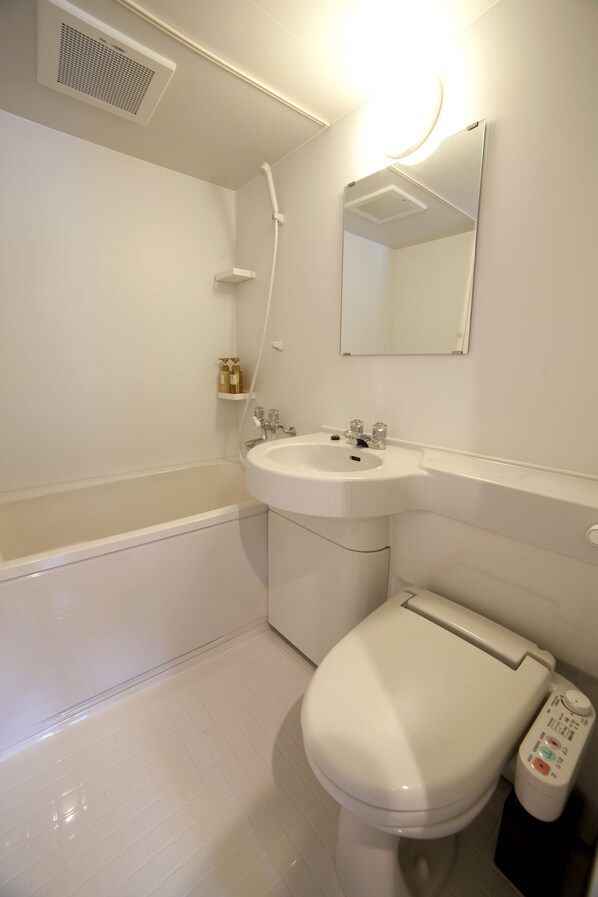 A bathroom with a white bathtub, sink, and toilet. - Fukuwauchi (Tokyo)