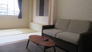 A modern living room with a sofa, a small table, and a remote control on the table. - Fukuwauchi (Tokyo)