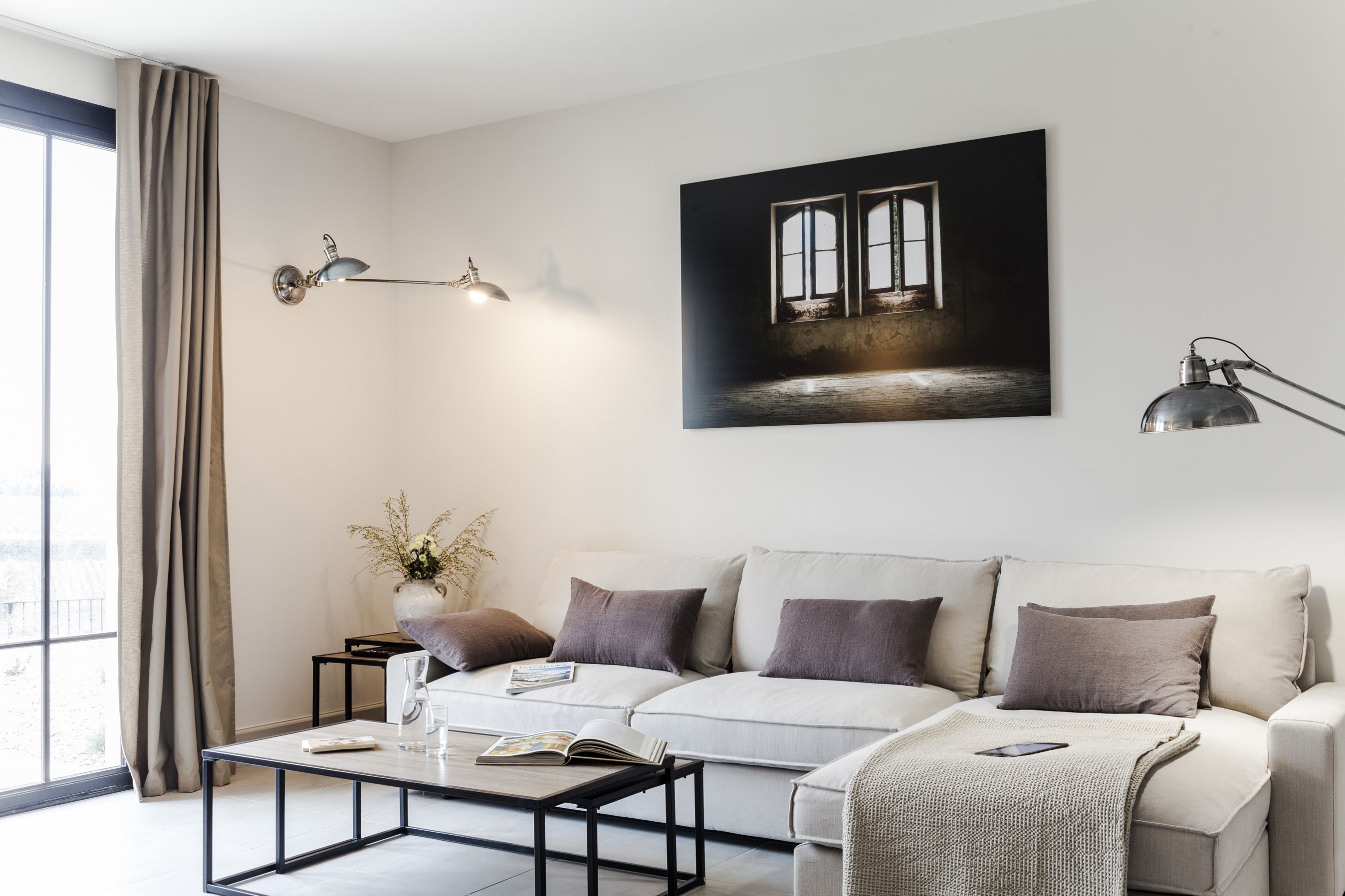 Una sala de estar moderna con un sofá, una mesa de centro y una obra de arte en la pared.