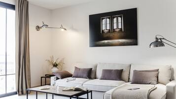 Una sala de estar moderna con un sofá, una mesa de centro y una obra de arte en la pared.