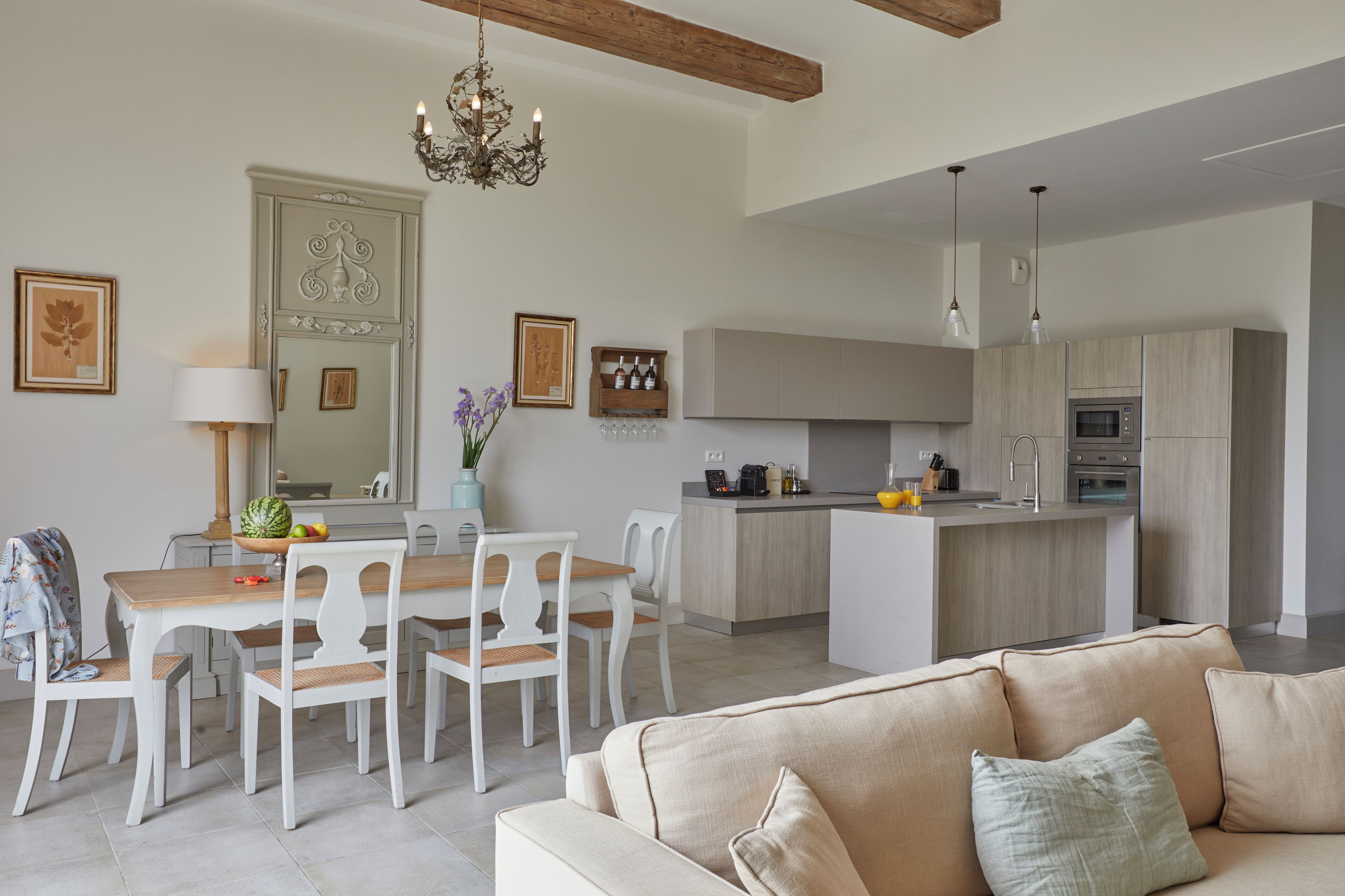 Een moderne keuken met een centraal eiland, witte kasten en een ingebouwde oven.
