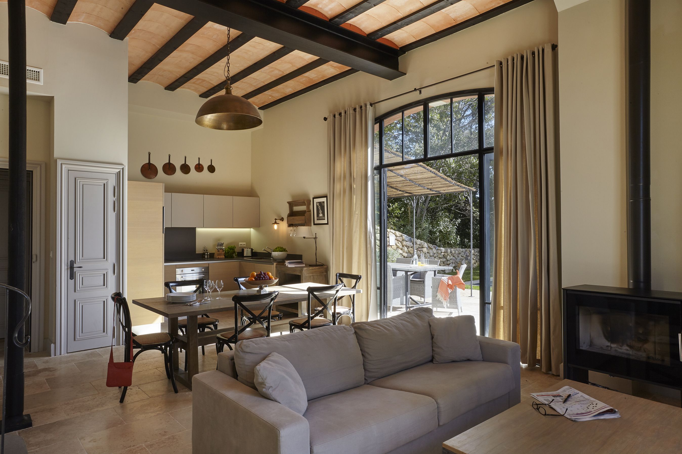 Amplia sala de estar con sofá, mesa de comedor y cocina al fondo.