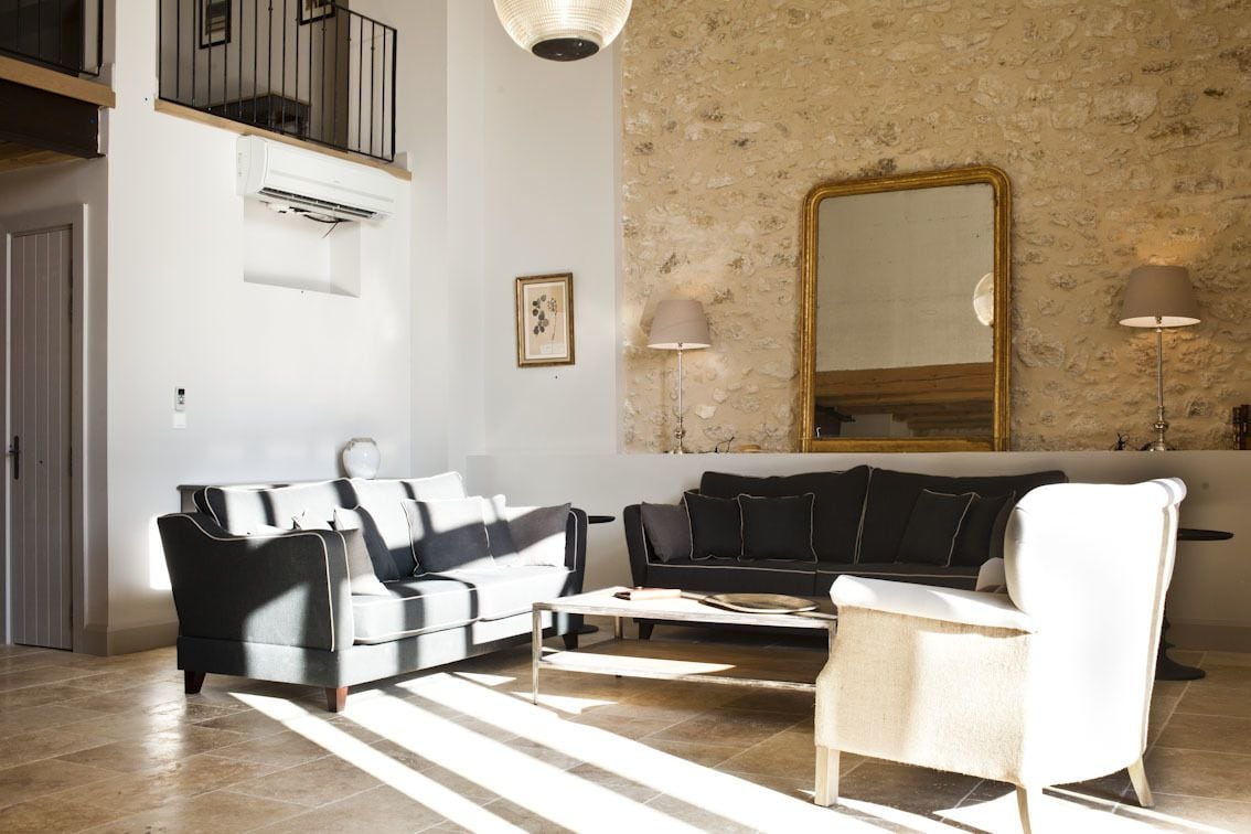 Una sala de estar con un sofá, una mesa de centro y un espejo grande en la pared.