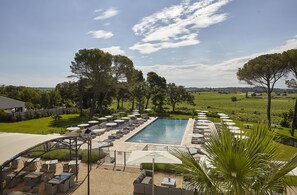 Relax by the resort's rectangular pool, surrounded by comfortable seating and shaded by umbrellas.