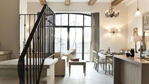 Amplia sala de estar con escaleras, un comedor y una cocina.