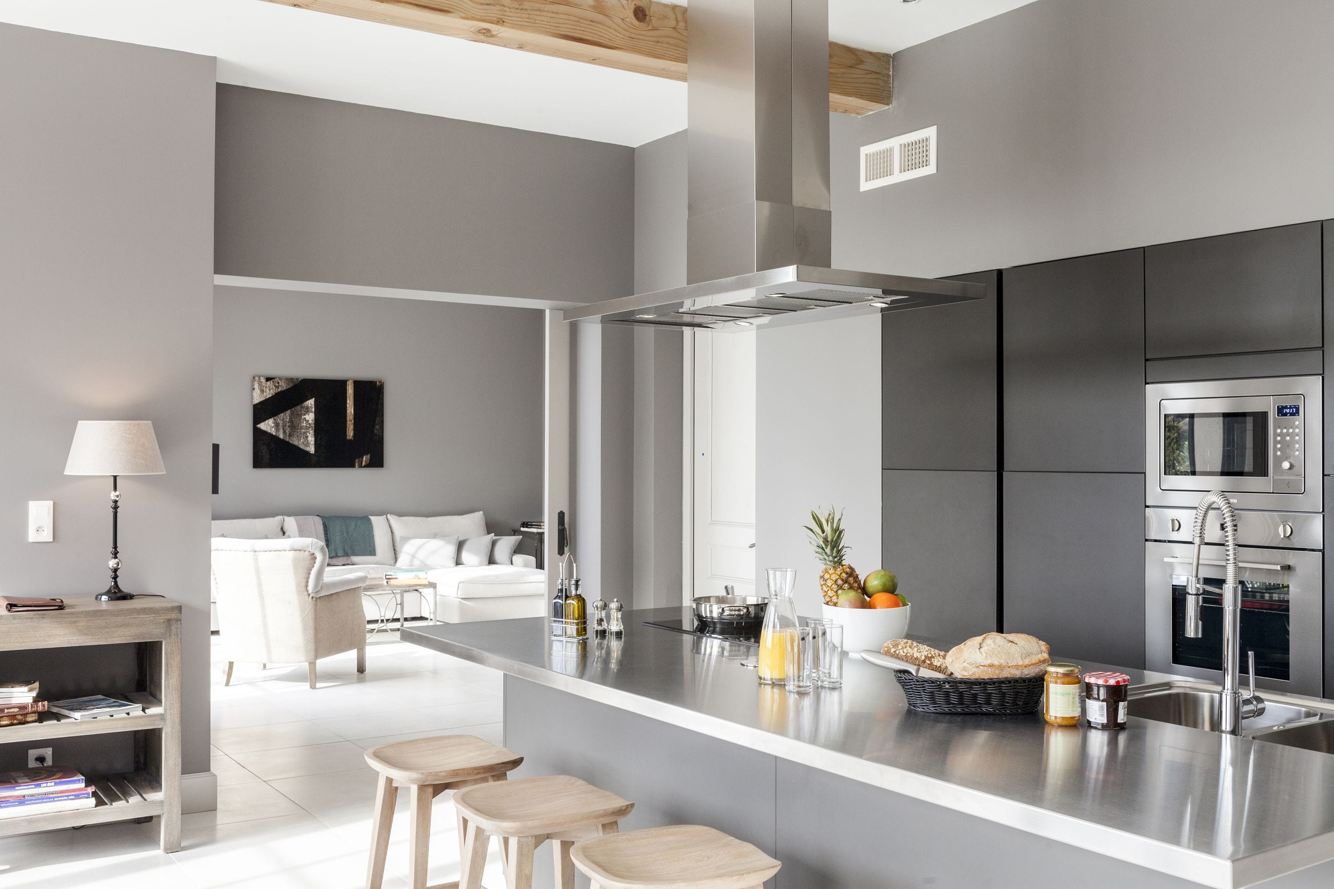 Une cuisine moderne dotée d’un îlot central, d’appareils électroménagers en acier inoxydable et d’un design minimaliste.