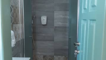 Een badkamer met een douche, toilet en wastafel.
