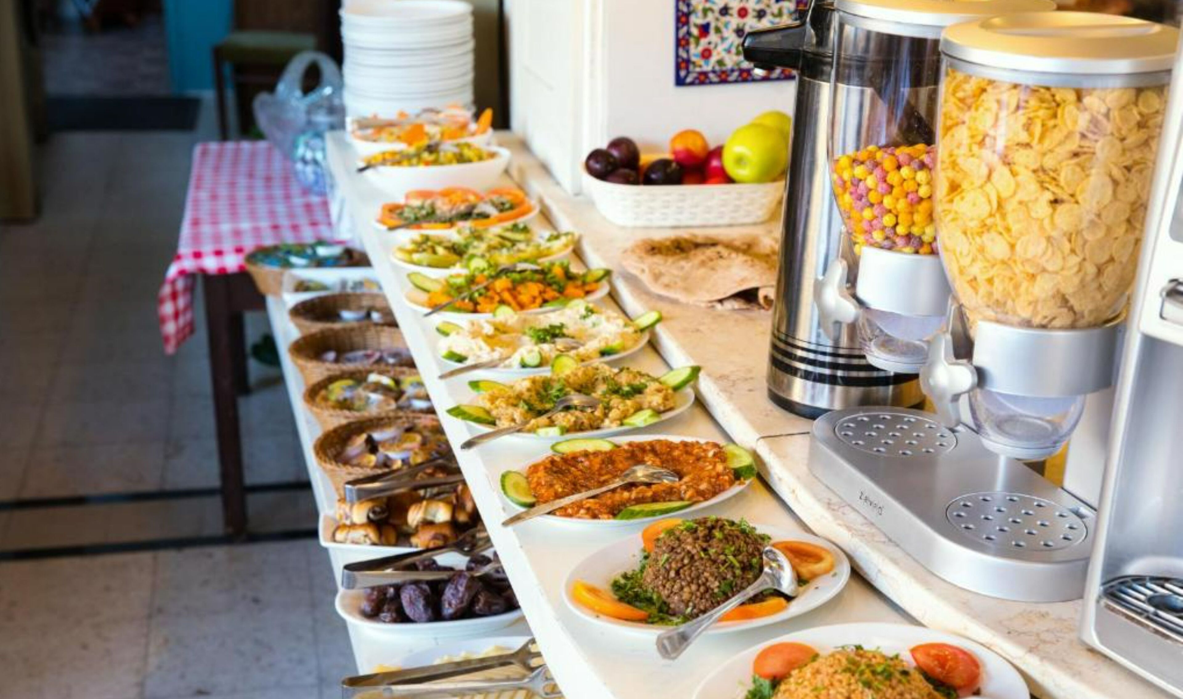 A buffet table with various dishes and a food dispenser.