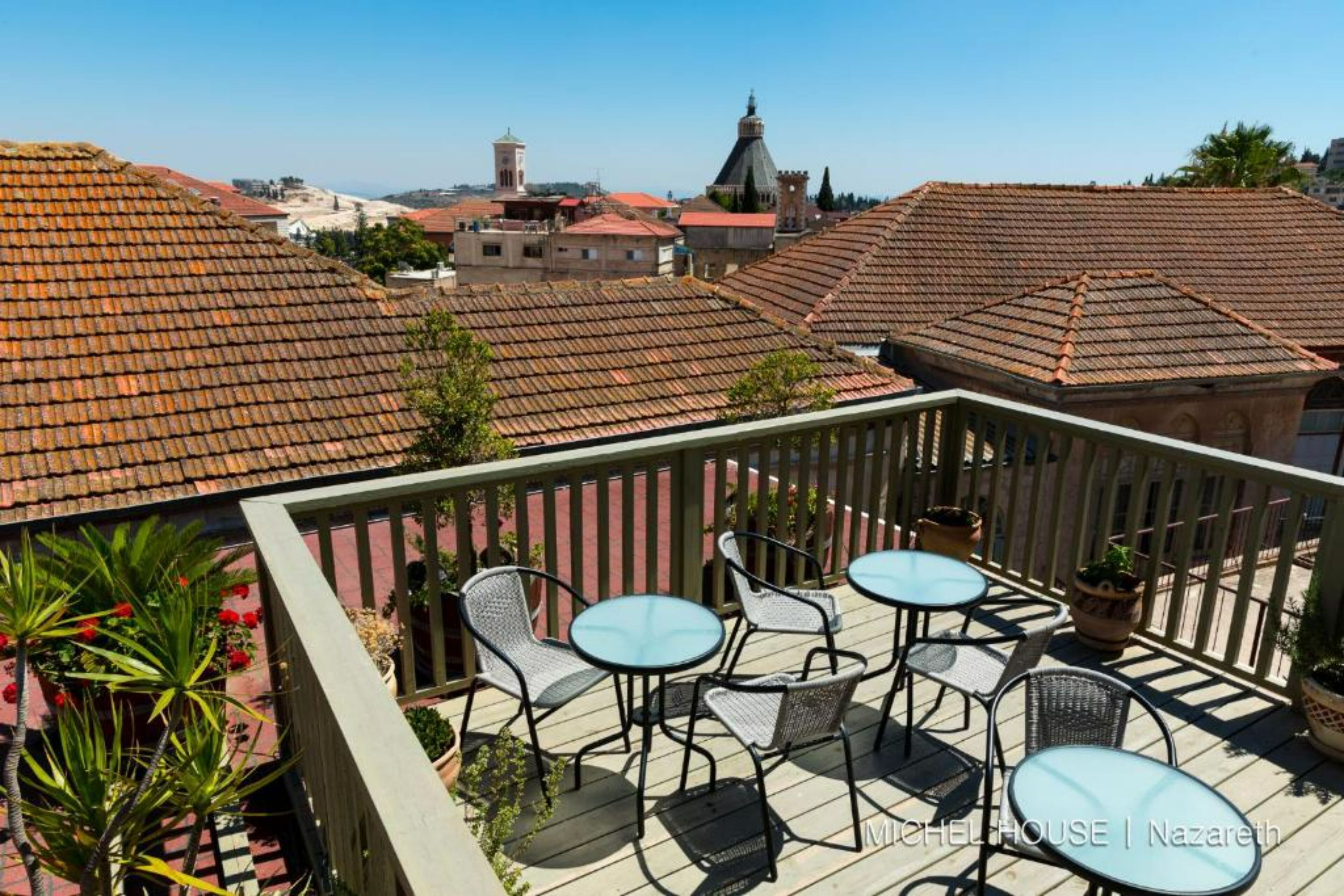 Terraço no telhado com área de estar externa e vista panorâmica da cidade.