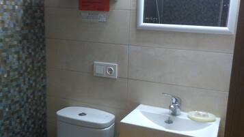 Un baño pequeño con inodoro, lavamanos y ventana.