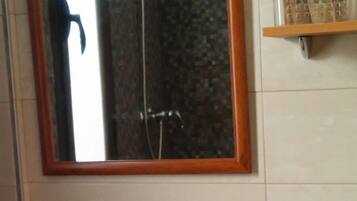 A bathroom with a white sink, a wooden vanity, a mirror with a wooden frame, and a towel rack with a towel.