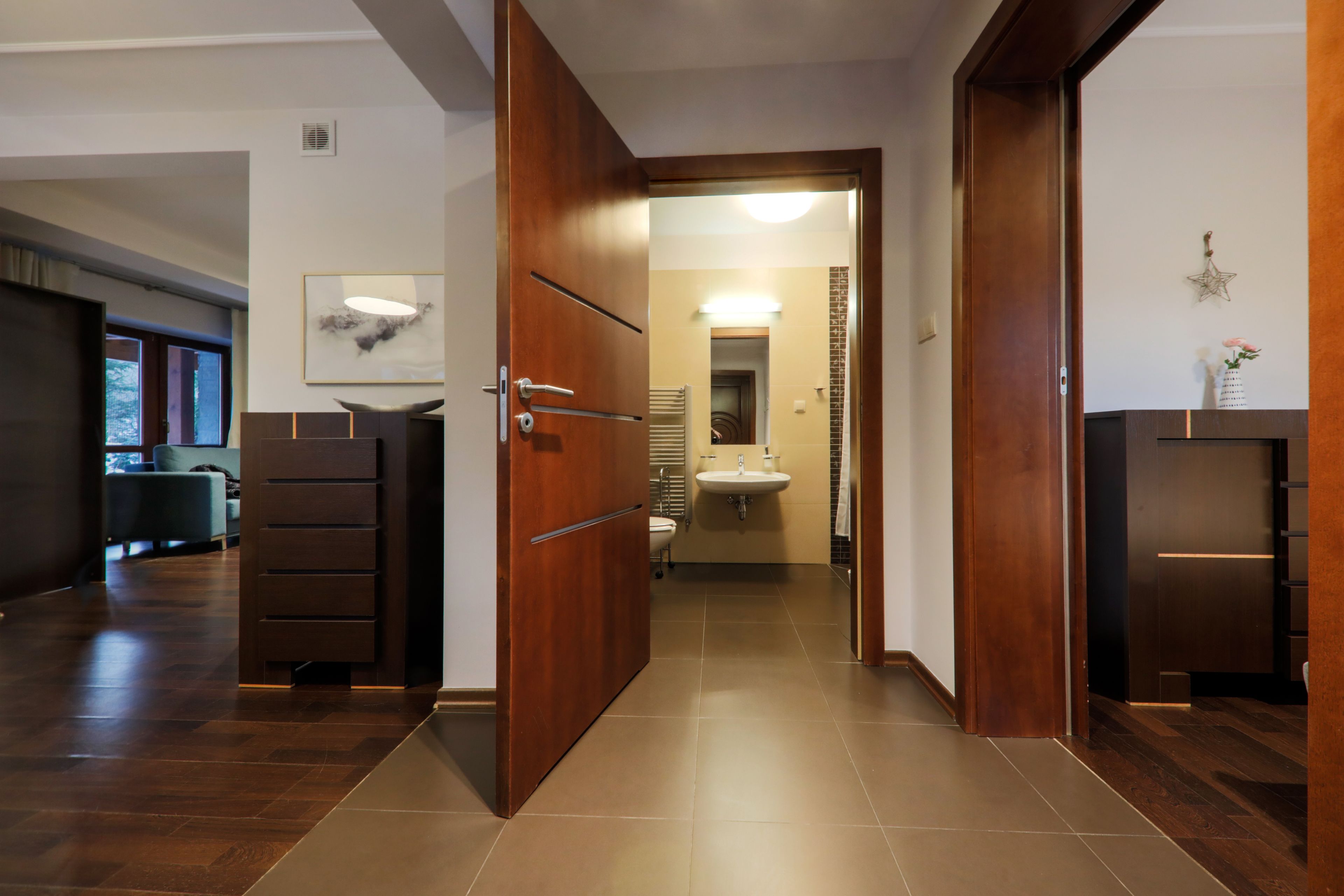 A modern bathroom with a sink, mirror, and towel rack.