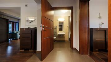 A modern bathroom with a sink, mirror, and towel rack.