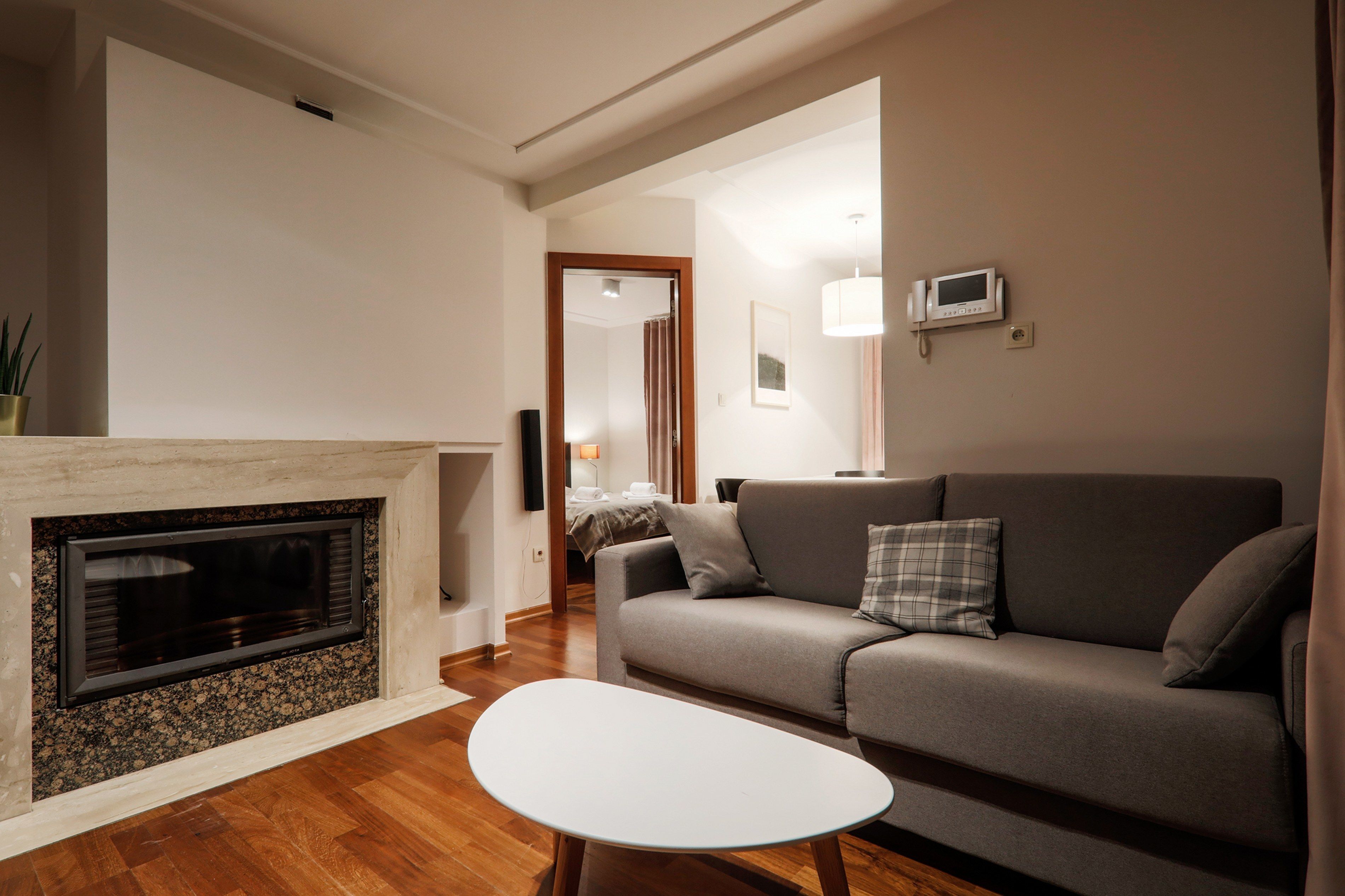 A living room with a fireplace, a sofa, a coffee table, and a television.