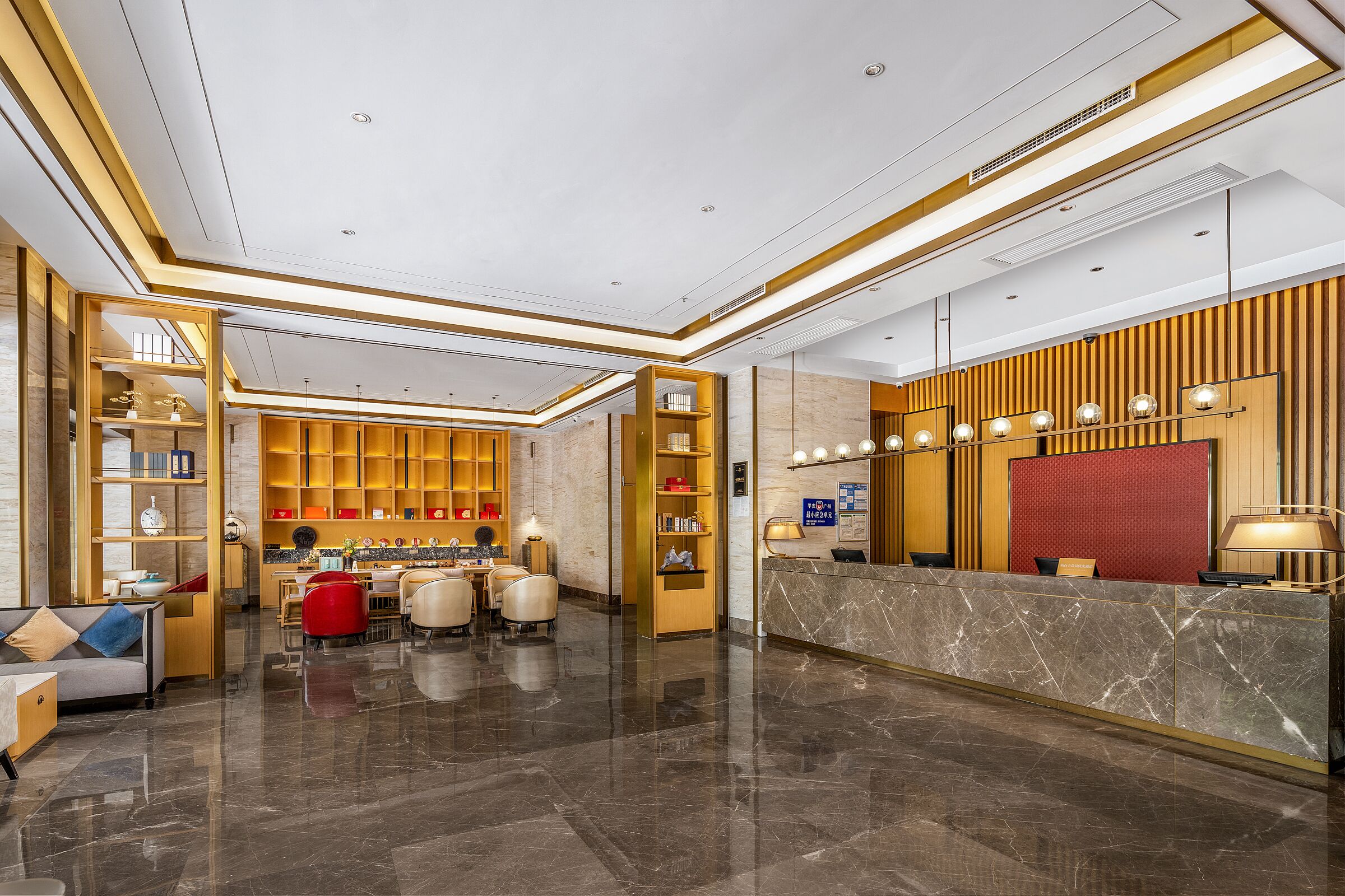 A modern hotel lobby with a reception desk, seating area, and a well-lit interior.