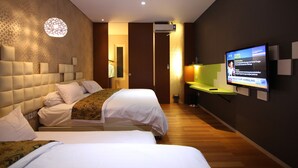 Une chambre d’hôtel avec deux lits, une télévision et un climatiseur fixé au mur.