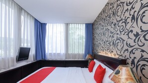 A hotel room with a bed, a desk with a laptop, and a lamp. - City Home Stay (Miri)