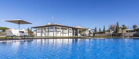 حمّام سباحة خارجي، مظلات على حمّام السباحة، مقاعد للتشمس