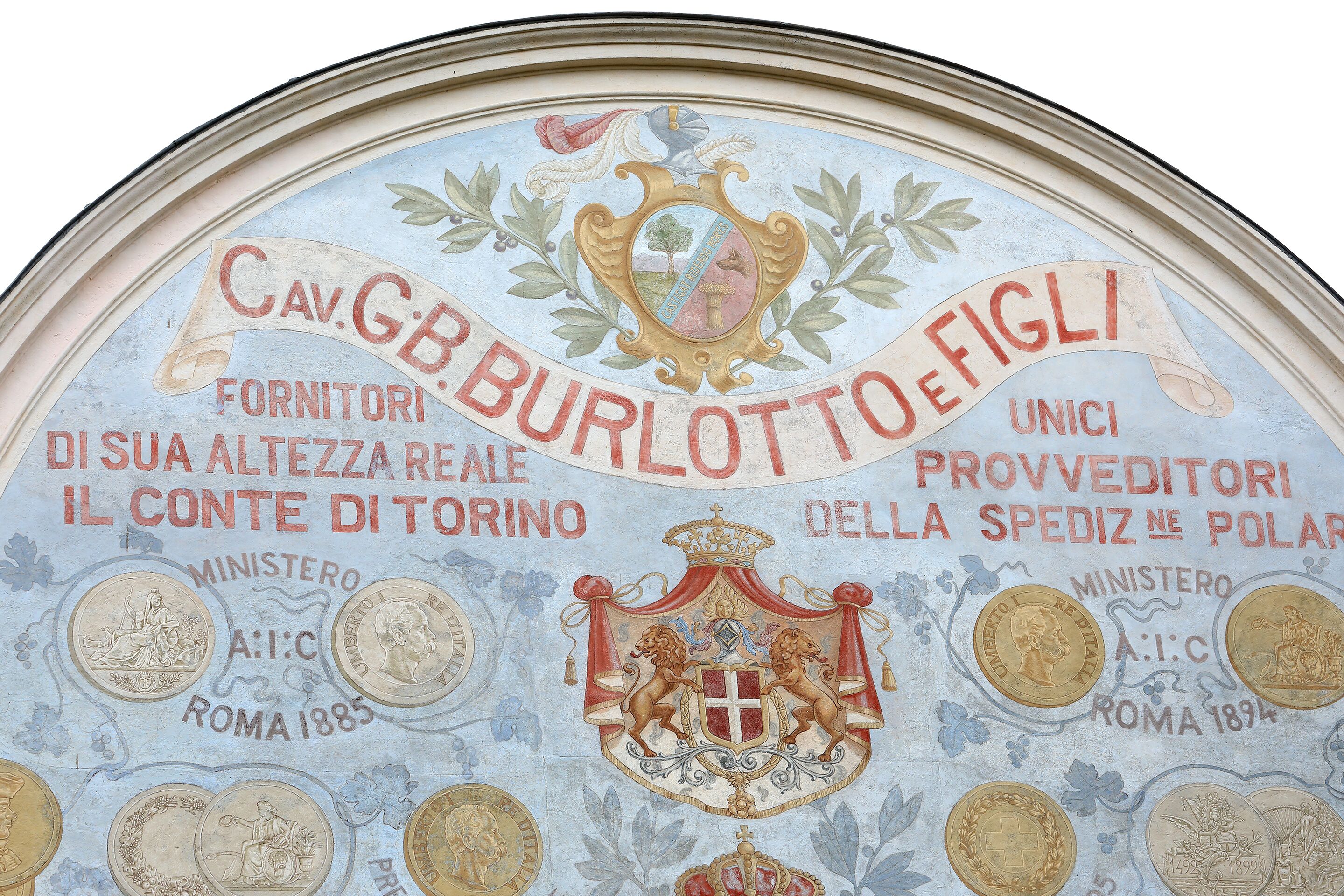 Un techo con un emblema decorativo y texto, incluyendo las palabras "Cav. GB Burlotto" y "Provveditori".