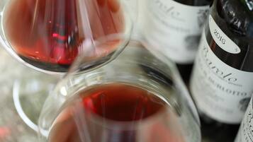 A close-up of wine glasses and bottles, with a focus on the labels and liquid.