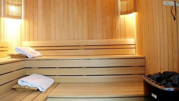 Una sauna de madera con bancos y un perchero para toallas.