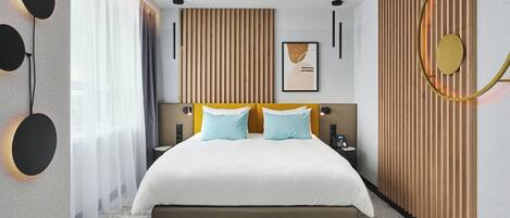 A modern hotel room with a large bed, a wooden panel wall, and a large window with curtains.